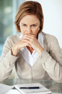 Concerned woman sitting down with hands towards her mouth